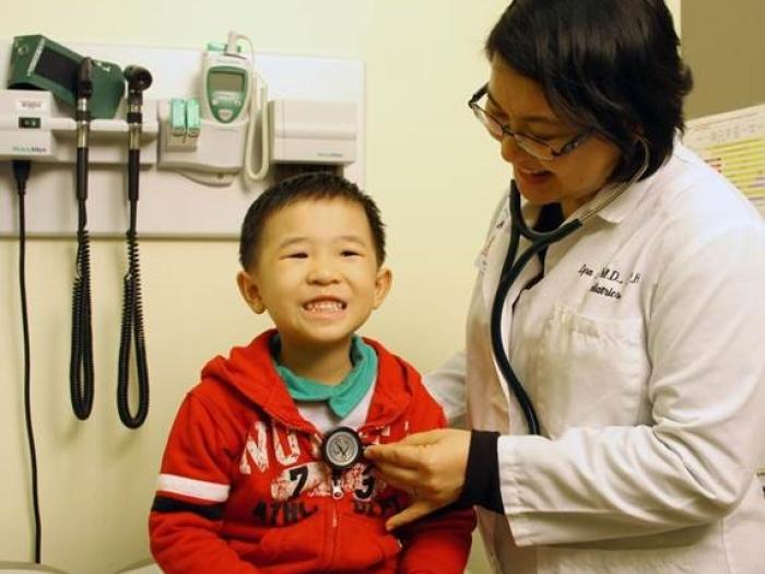 doctor examining smiling child